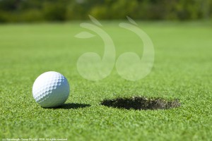 Golf ball near hole on a green