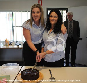 Samm Turri and Yvette Taylor cutting the cake for the volunteers of TransCare.