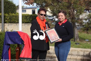 Aunty Jean Hands giving Caitlin Albury, granddaughter of Kevin Albury the certificate of recognition.