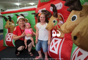 Lee Watts with Alyssa Starling and Isabella Ward checking out the reindeer stable before their photo with Santa.