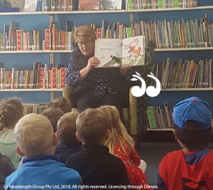 Cr Lee Watts reading a story to children in the Scone library.